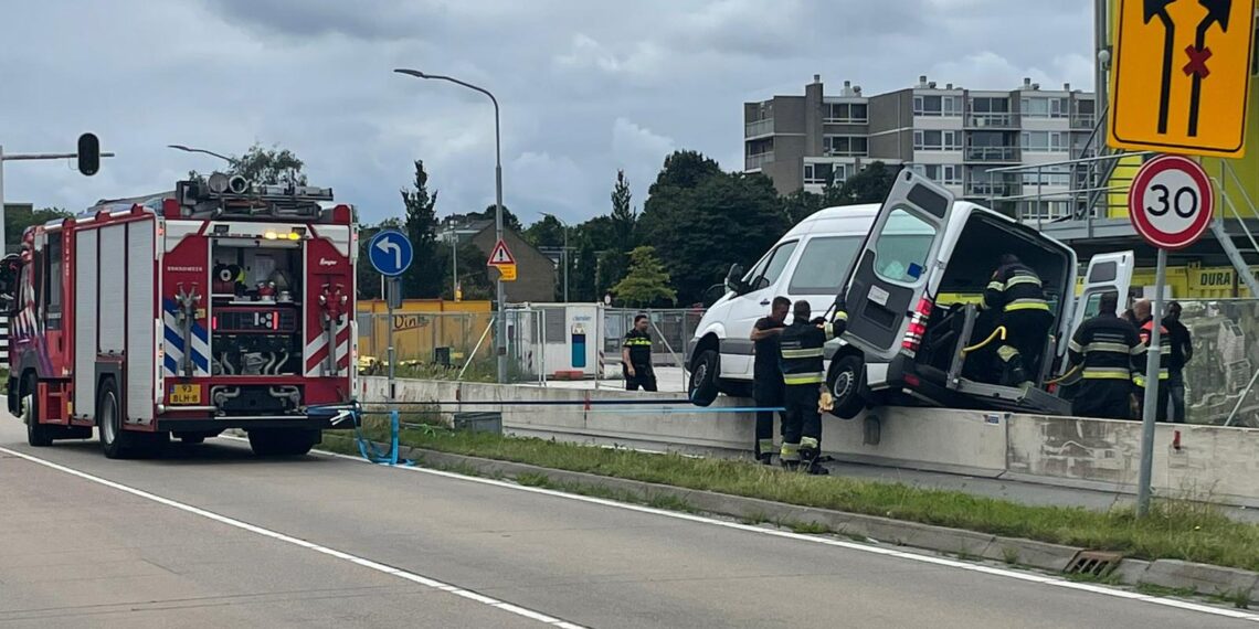 Rolstoeltaxi belandt op betonblokken, brandweer haalt man uit busje