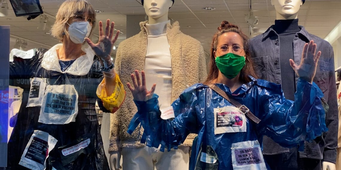 ‘Anti-Black Fridayactie’ in Haarlem: actievoerders lijmen zich vast aan winkelruit