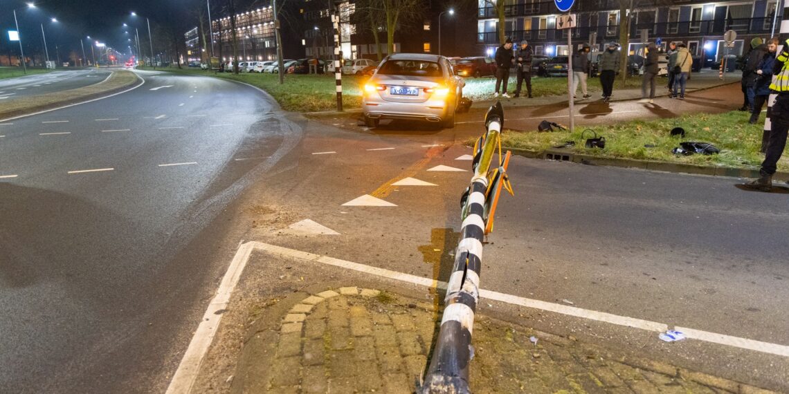 Taxi rijdt verkeerslicht uit de grond op Vondelweg in Haarlem